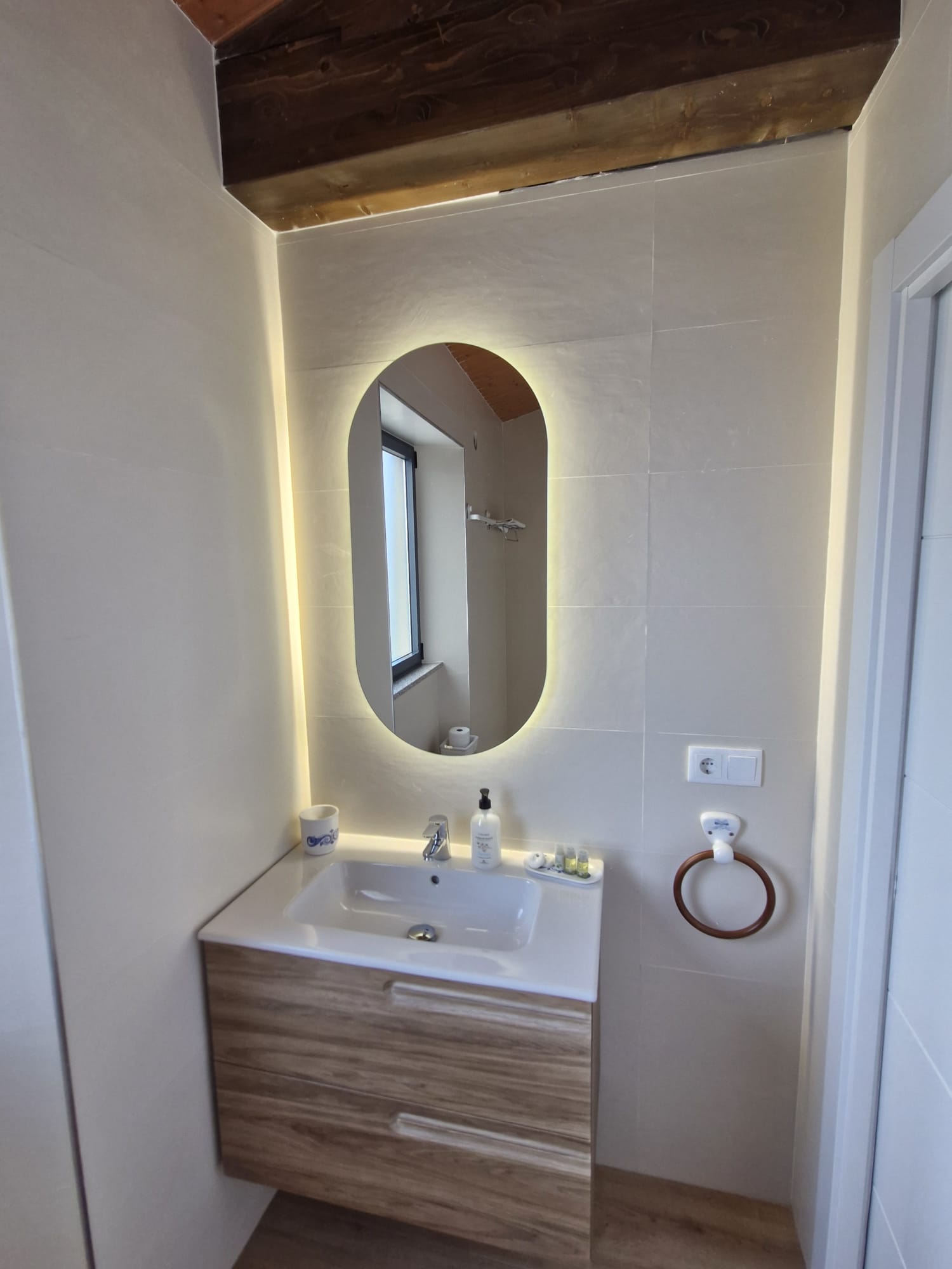 Lavabo con espejo ovalado retroiluminado del baño principal