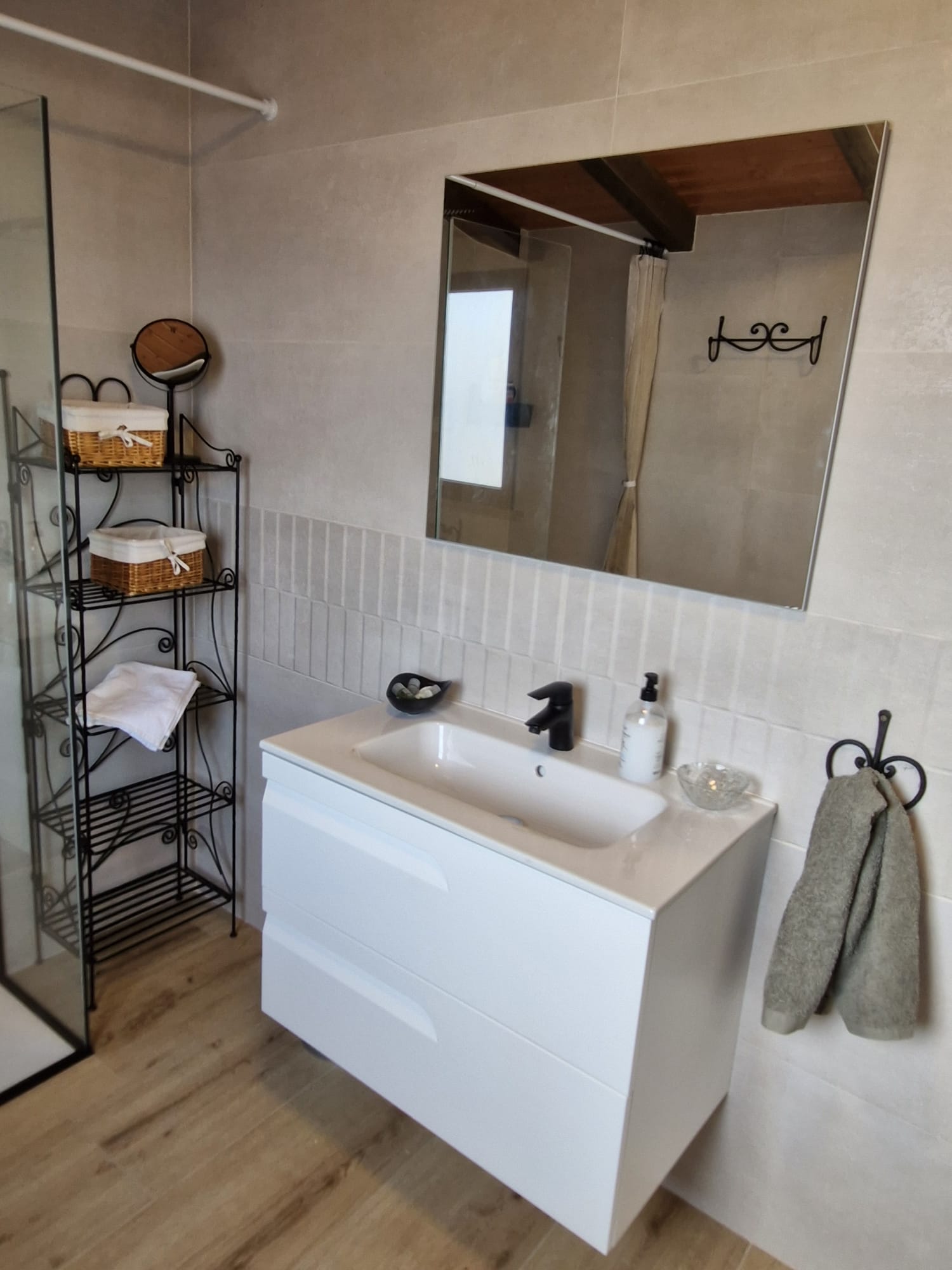 Lavabo con mueble blanco y estantería de ratán