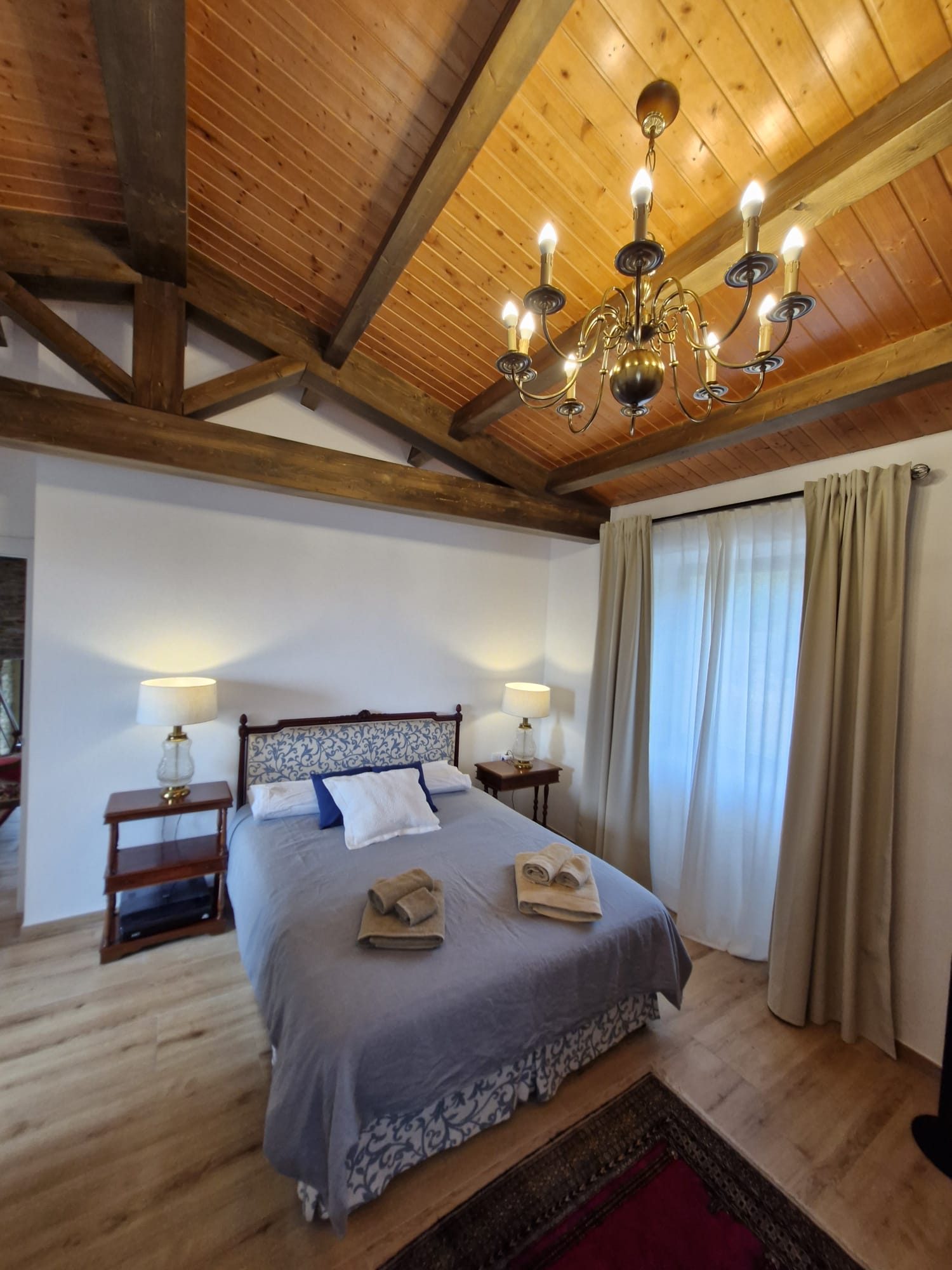 Habitación principal, cama con toallas y candelabro de techo