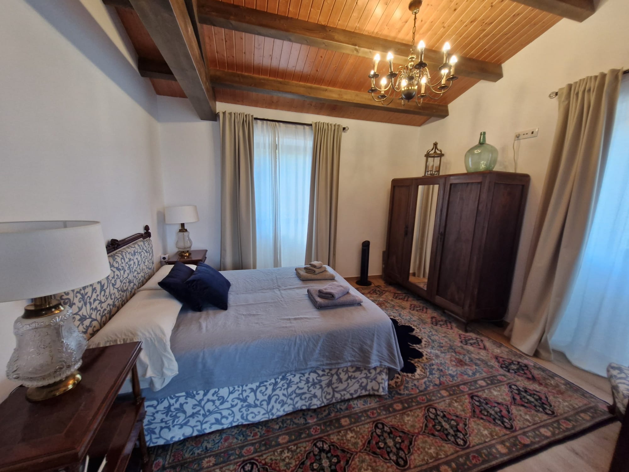 Habitación principal con armario antiguo y alfombra persa
