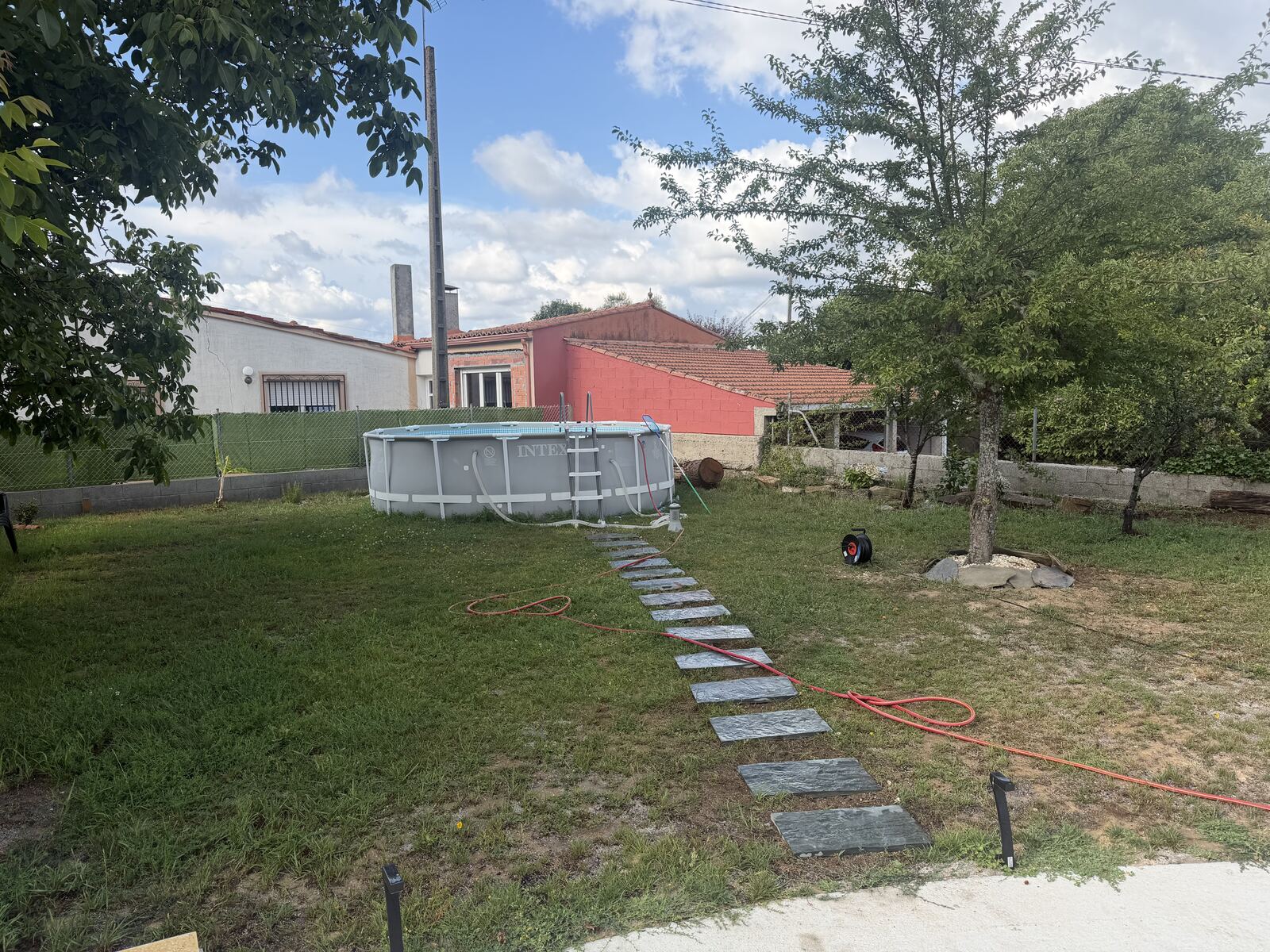 Piscina desmontable en el jardín con camino de piedra