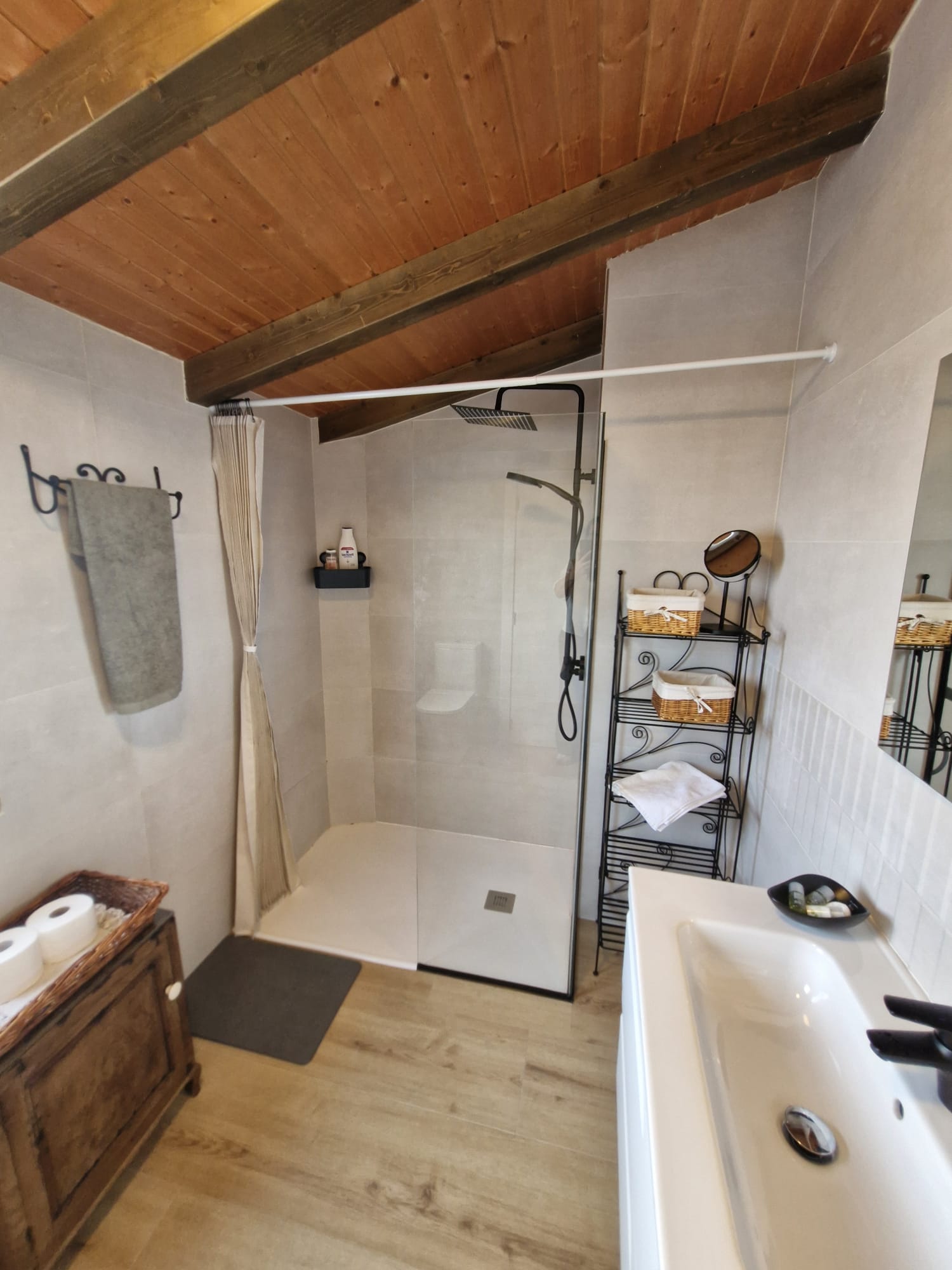 Ducha con grifo negro y mampara de la habitación de camas individuales